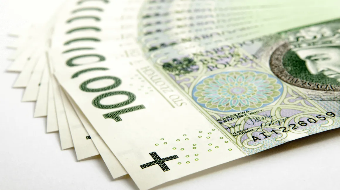 Rozłożone w wachlarz polskie banknoty 100 zł, symbolizujące większą kwotę gotówki lub finansowe wsparcie.